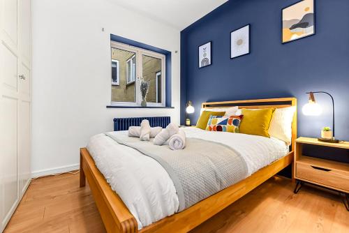 um quarto com uma cama grande e uma parede azul em Spacious Contemporary 2 bed flat, Central London em Londres