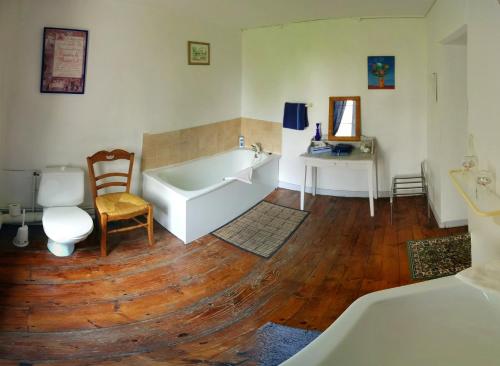 a bathroom with a tub and a wooden floor at Chateau De Grosfy in Hugleville-en-Caux