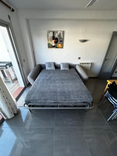 ein großes Bett in einem Zimmer mit Sofa in der Unterkunft MAISON au bord du canal !!! in Roses
