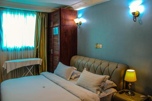 um quarto com uma cama e uma janela em Residence Le Carat em Douala