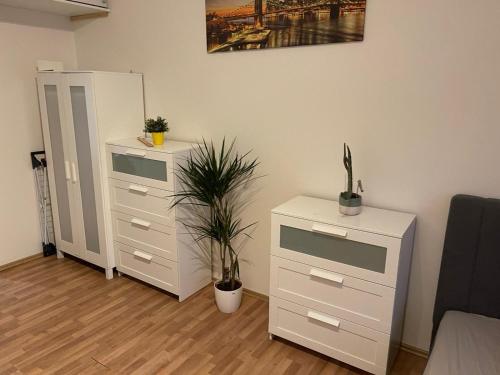 a room with two dressers and a cabinet with plants at Sunlit apartment close to city center in Prague