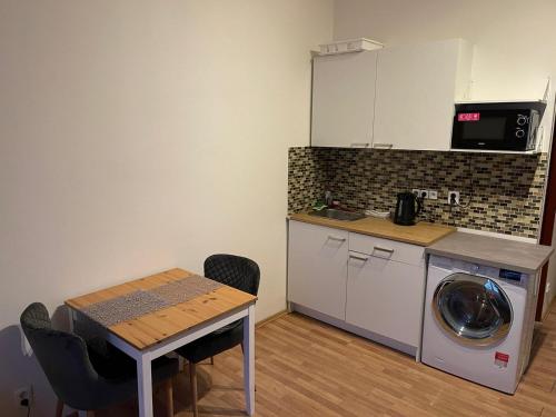 a kitchen with a washing machine and a table at Sunlit apartment close to city center in Prague