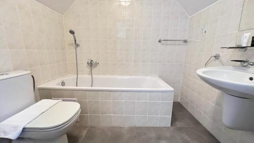 a bathroom with a tub and a toilet and a sink at Hotel PAYER in Teplice