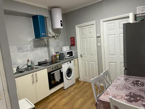a kitchen with a sink and a washing machine at Leman House in London