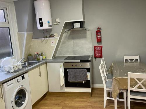 a kitchen with a stove top oven next to a table at Leman House in London