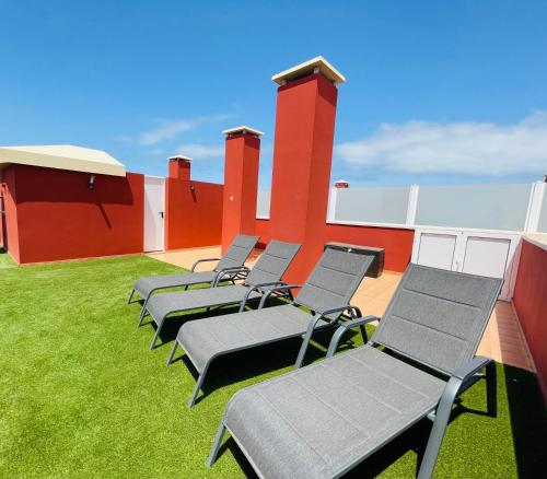 a row of chaise lounge chairs on a roof at Casa Vista Calma Cotillo Country El Cotillo in Cotillo