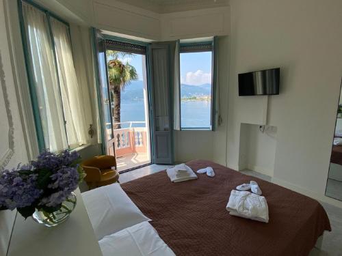 a hotel room with a bed with towels on it at Luxury Villa Olga in Stresa in Baveno