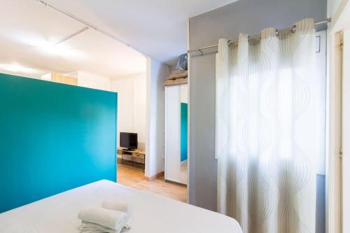 sypialnia z białym łóżkiem i niebieską ścianą w obiekcie One bedroom flat in Sant Andreu with small terrace w Barcelonie
