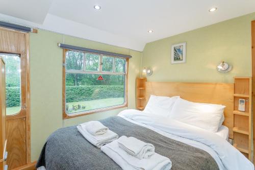 a bedroom with a bed with towels on it at Carriage 1 - Coalport Station Holidays in Telford