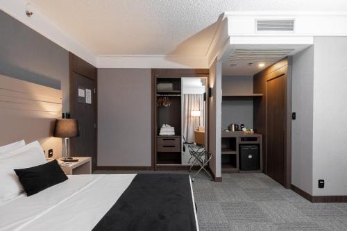 a bedroom with a bed and a desk in a room at Slaviero Guarulhos Aeroporto in Guarulhos