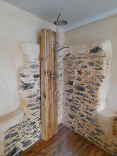 eine Dusche im Bad mit einer Steinmauer in der Unterkunft Les Forges 2 in La Luzerne