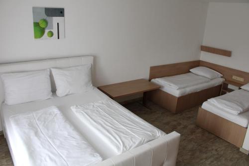 a small room with two beds and a table at Apparthotel Alte Innbrücke-24Std-Self-Check in-Haustiere Willkommen in Neuhaus am Inn
