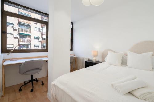 1 dormitorio con cama, escritorio y ventana en For You Rentals Central Apartment Atocha Station Madrid TEL3 en Madrid