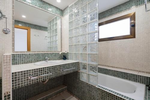 uma casa de banho com uma banheira, um lavatório e um espelho. em For You Rentals Central Apartment Atocha Station Madrid TEL3 em Madri
