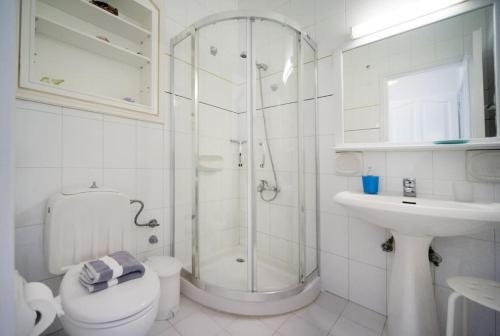 e bagno con doccia, servizi igienici e lavandino. di Avlaki Beach House,stylish villa in Kassiopi a Kassiopi