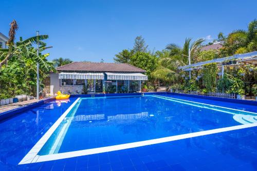 a large blue swimming pool with a gazebo at Sanssouci Kep in Kep