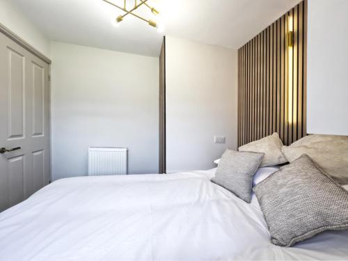um quarto com uma grande cama branca e 2 almofadas em SoulFul Stays Chelmsford em Broomfield