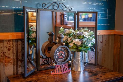 a table with a clock and flowers on it at The Carriage at Creagan in Creagan