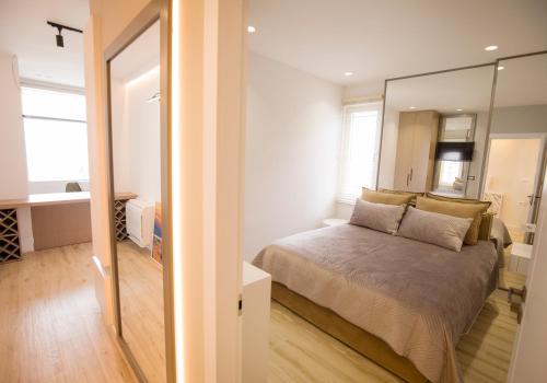 een slaapkamer met een bed en een grote spiegel bij Tola Apartaments in Pogradec