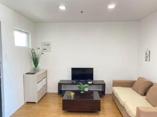 ein Wohnzimmer mit einem Sofa und einem TV in der Unterkunft SK's Crib - Fully Furnished Condo @ Primavera Apts in Cagayan de Oro