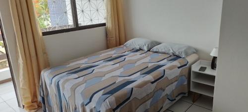 Ce lit se trouve dans une petite chambre dotée d'une fenêtre. dans l'établissement Quarto inteiro com banheiro privativo, à Salvador