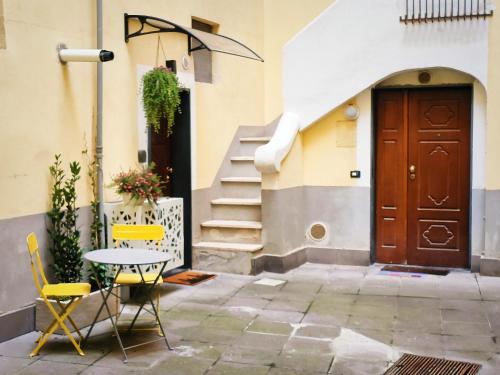 un tavolo e sedie di fronte a un edificio con porta di IN URBS a Salerno