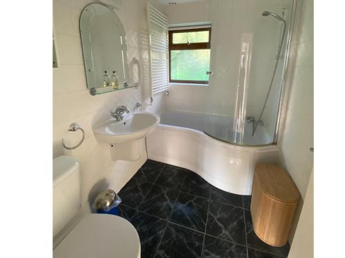 uma casa de banho com uma banheira, um lavatório e um WC. em Arbor Cottage em Eastbourne