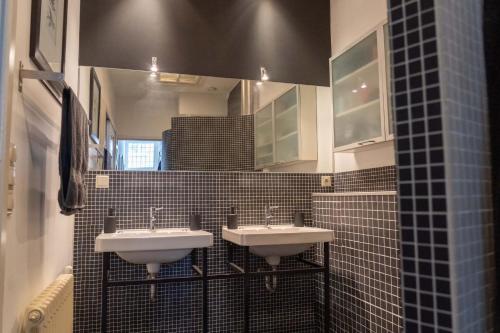 een badkamer met 2 wastafels en een spiegel bij Het Kasteeltje in Vlissingen