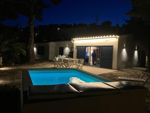 un uomo che sta fuori da una casa con una piscina di notte di Let's Holidays 7 Xemeneies house a Tossa de Mar