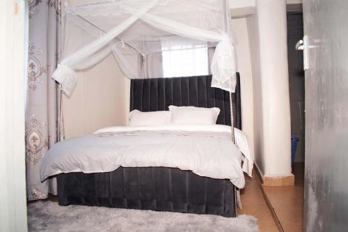 a bedroom with a large bed with a canopy at Zuriel Homes 1 Bedroom apartment in Kakamega
