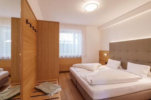 sypialnia z 2 łóżkami i zagłówkiem w obiekcie Ferienhaus Törggelehof w mieście Tscherms