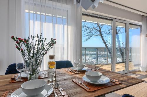 a dining room table with a view of the ocean at Apartament Szafirowy z BEZPOŚREDNIM WIDOKIEM na morze- Nadmorski Luksus Apartamenty in Ustronie Morskie