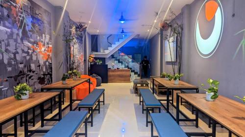 um restaurante com mesas de madeira e cadeiras azuis em Base Backpackers em Cidade de Ho Chi Minh