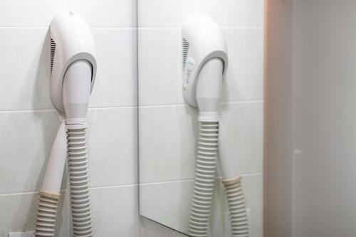 two white phones hanging on a wall in a bathroom at Hotel Imperial ***S in Garda