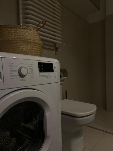 een badkamer met een wasmachine en een toilet bij Kraków Piano Apartment in Krakau