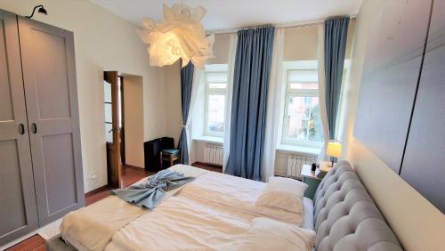 um quarto com uma cama grande e um cobertor azul em Rudi4 Luxury Vilnius Apartment em Vilnius