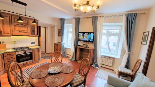 uma cozinha com mesa e cadeiras num quarto em Rudi4 Luxury Vilnius Apartment em Vilnius