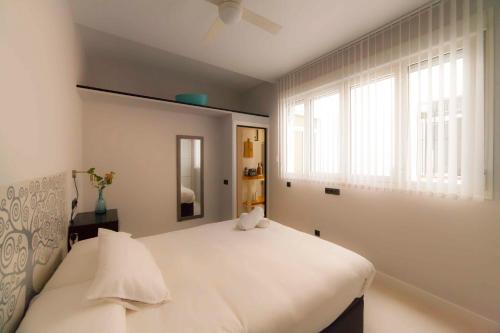 1 dormitorio con cama blanca y ventana en Modern apartment in City Centre en Sevilla