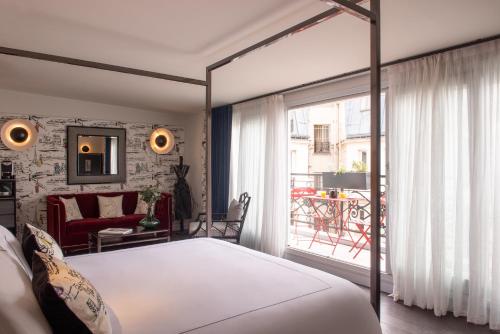 a bedroom with a large bed and a balcony at Mom'Art Hotel in Paris