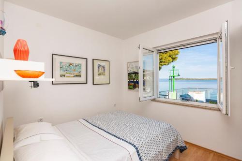 a bedroom with a bed and a window at House with pool by the sea - Dugi otok, Žman in Žman