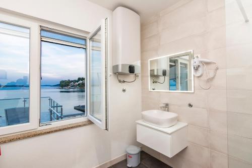 a bathroom with a toilet and a window at House with pool by the sea - Dugi otok, Žman in Žman
