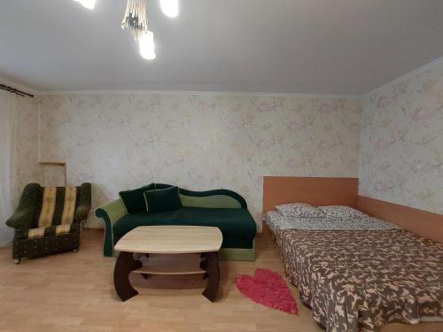 - une chambre avec deux lits, un canapé et une table dans l'établissement Апартаменти економ, à Loutsk