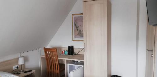 um quarto com uma cama e uma secretária com uma cadeira em Pension Lilli em Norddeich