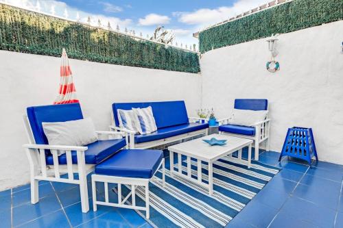 アロナにある2 bedrooms appartement with shared pool furnished terrace and wifi at Costa del Silencio 1 km away from the beachのパティオ(青と白の椅子、テーブル付)