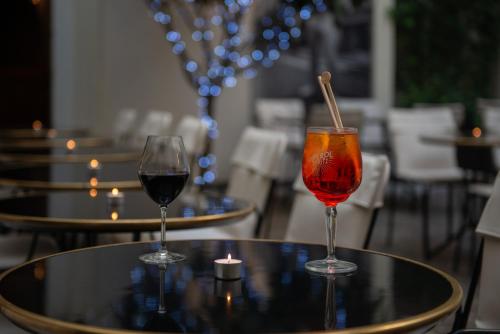 two glasses of wine sitting on a table at Mom'Art Hotel in Paris