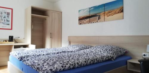 a bedroom with a bed with a blue comforter at Pension Lilli in Norddeich