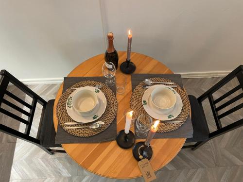 a wooden table with two plates and a bottle of wine at Linkuva Manor Apartment in Kaunas