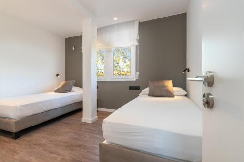 1 dormitorio con 2 camas y ventana en Marisan, en Vall-Llobrega