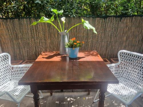 a wooden table with a vase with flowers on it at VILLA VILLACOLLE in Procchio