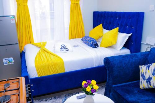 a blue bed with yellow curtains and a blue chair at Enac Homes - Classy, Elegant Executive Studios - Kiambu Road in Kiambu
